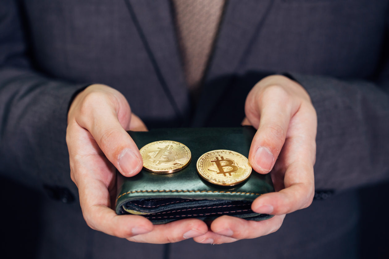Close-up of businessman with wallet receiving and paying by bitcoin or cryptocurrency - crypto currency is the future of digital cashless financial banking trade