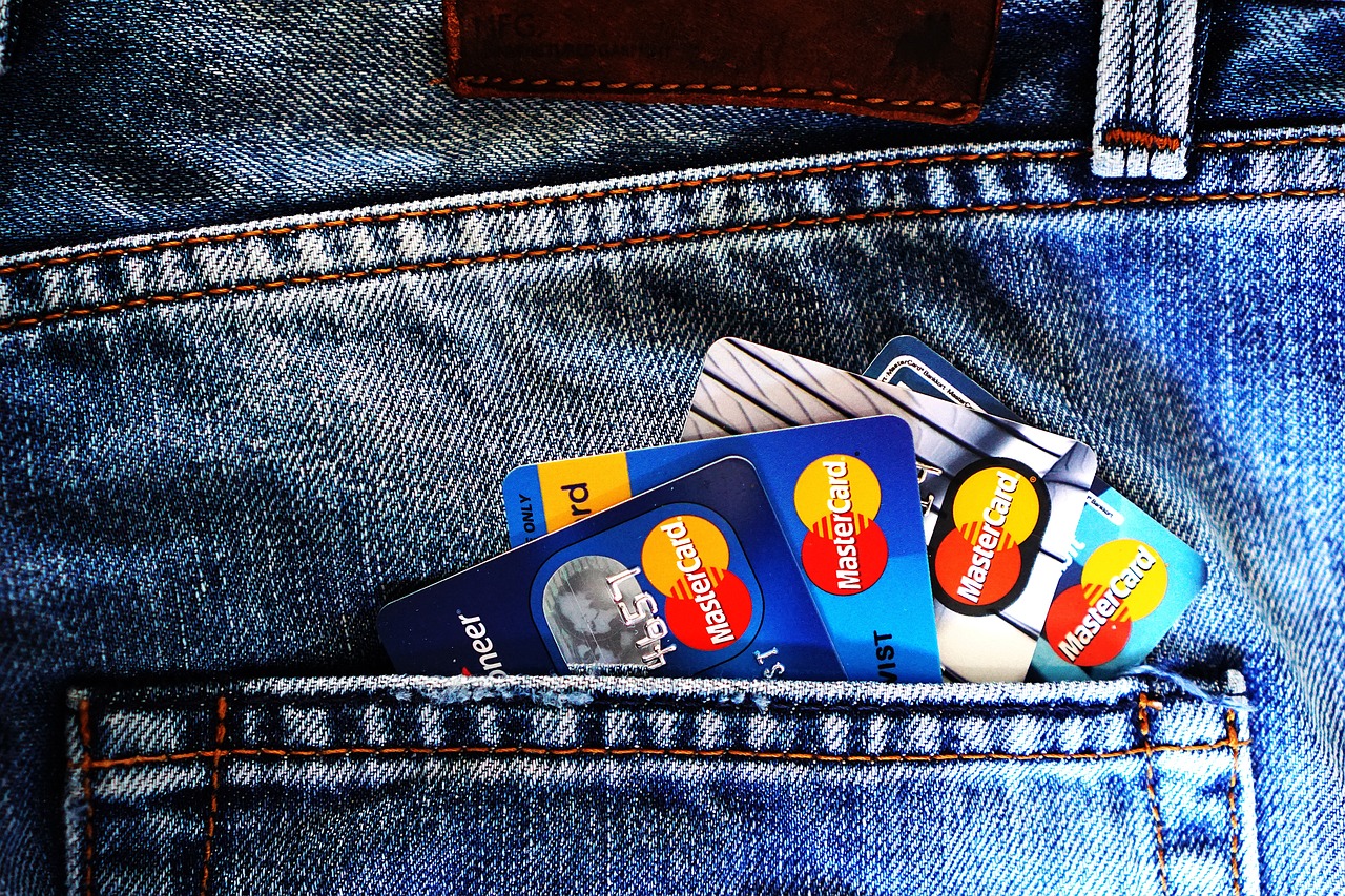 A denim blue jeans pocket with a fan of Mastercard credit cards