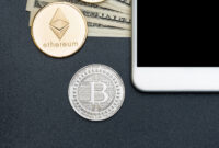 Top view crypto currency Silver Bitcoin,Ethereum and blank mobile screen on dollar banknote on black table,Virtual digital money.mock up screen for display design